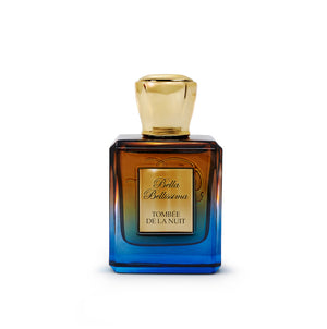 Tombee de la Nuit fragrance by Bella Bellissima, presented in a shaded glass bottle from brown down into deep blue colour, with a gold cap and an engraved plaque.